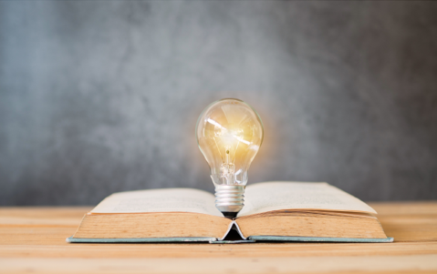 Illuminated lightbulb in center of an open book